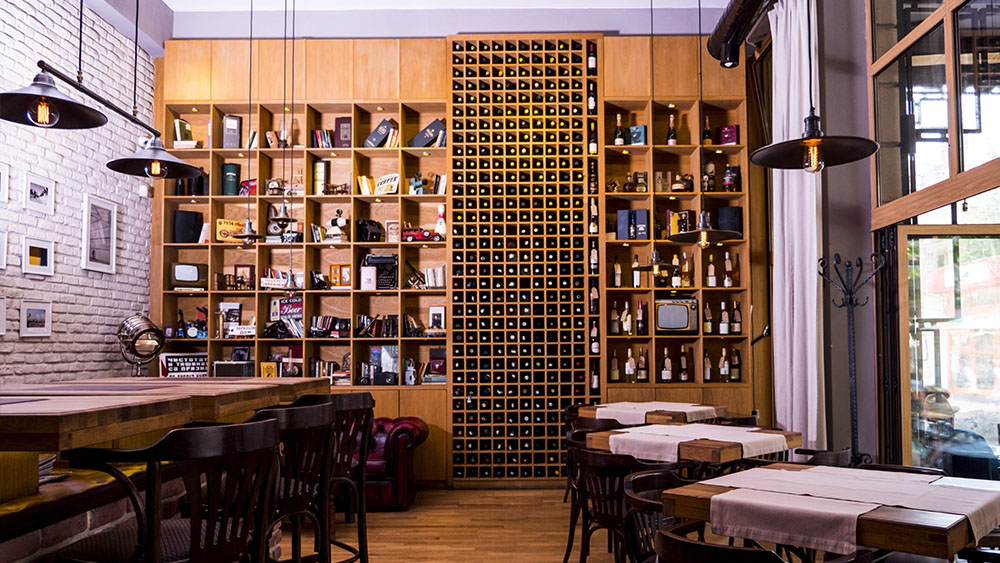 Ti Bar interior in Burgas with book shelves and a wall of wine bottles